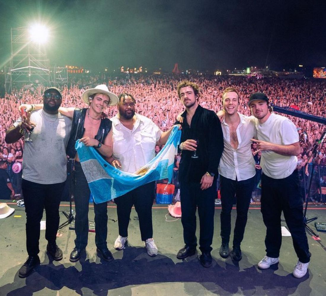 La banda con la bandera argentina despidiendose del publico